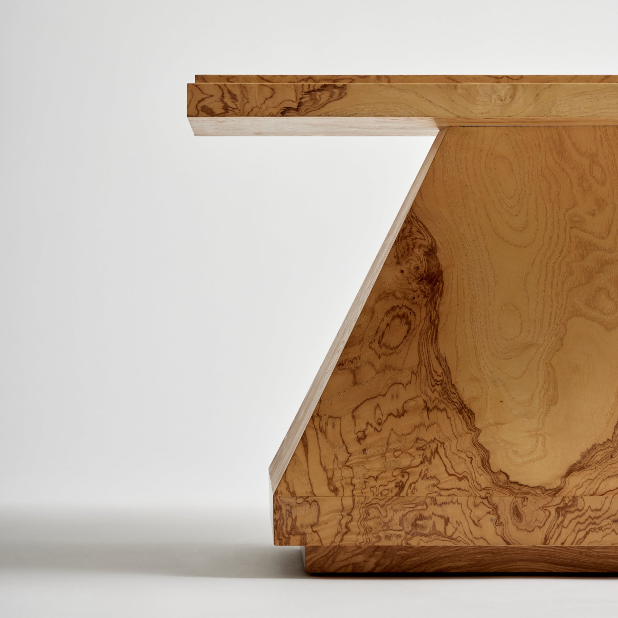 Olive burl table with a wood base on a white background